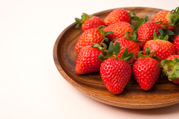 Fresh strawberries in wooden bowl on white background 