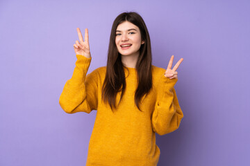 Young Ukrainian teenager girl over isolated purple background showing victory sign with both hands