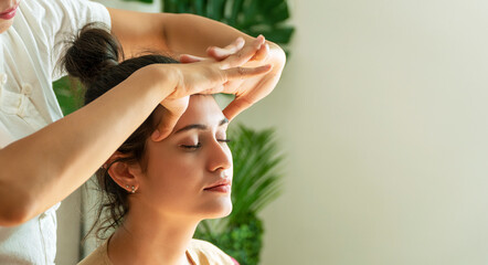 Healthcare spa and massage thai concept. Close up hands of thai masseuse woman getting massage head for customer. Face massage treatment in the spa salon, Girl receiving holistic massage treatment.