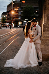 Fototapeta premium Beautiful bride and groom embracing and kissing on their wedding day outdoors