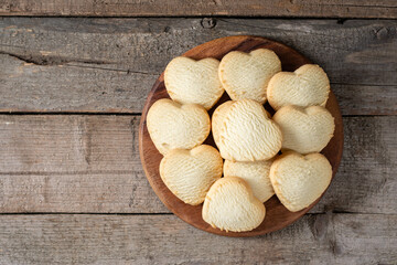 Lemon cookies. Lemon cookie hearts on a round serving board on a brown wooden table. Cookies for Valentine's Day. Top view with copyspace
