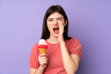 Young Ukrainian teenager girl holding a cornet ice cream over isolated purple background shouting with mouth wide open