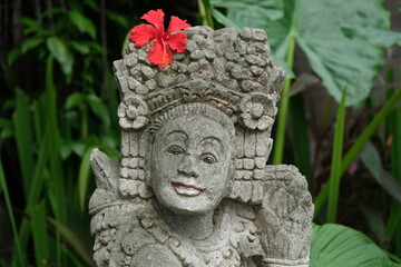 Indonesia Bali - Ubud Handmade Balinese stone statue with red Hibiscus flower