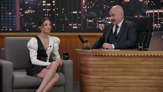 FIXED Late-night talk show host showing a green board with tracking points to celebrity guest in a studio. TV broadcast style show. Shot with RED cinema camera