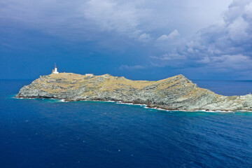 Drone view from  île de la Giraglia on the northern tip of Cap Corse, famous for its lighthouse and Genoese tower, both of which are historical monuments. Barcaggio village, Corsica, France