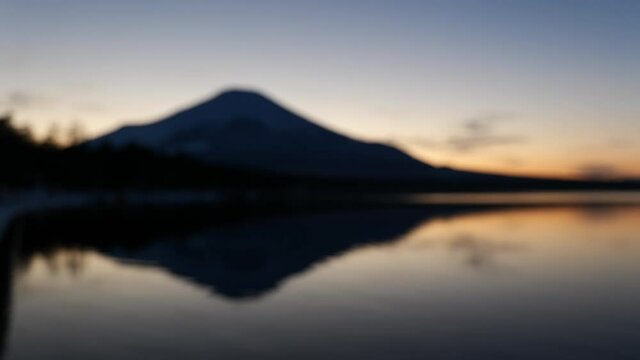 湖に反射する夕焼け空と富士山の背景ボケ映像（ループ素材）