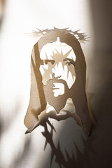 Jesus Christ face paper template and shadow with thorn crown as christian religion savior God, suffering on Good friday and crucifixion