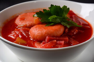 Hot red beet Kubbeh soup, a famous middle eastern dumplings soup dish, served in a bowl. A Jewish-Iraqi traditional matfuniya winter soup. Levantine dish made of bulgur, minced onions, ground  beef