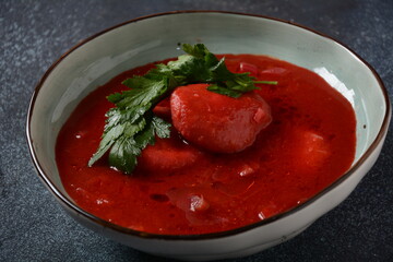 Hot red beet Kubbeh soup, a famous middle eastern dumplings soup dish, served in a bowl. A Jewish-Iraqi traditional matfuniya winter soup. Levantine dish made of bulgur, minced onions, ground  beef