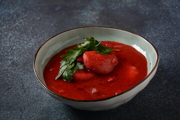 Hot red beet Kubbeh soup, a famous middle eastern dumplings soup dish, served in a bowl. A Jewish-Iraqi traditional matfuniya winter soup. Levantine dish made of bulgur, minced onions, ground  beef