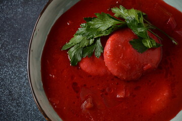Hot red beet Kubbeh soup, a famous middle eastern dumplings soup dish, served in a bowl. A Jewish-Iraqi traditional matfuniya winter soup. Levantine dish made of bulgur, minced onions, ground  beef