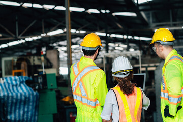 Work at factory.engineer woman and workers man team working together in safety work wear with white and yellow helmet using laptop computer.in factory workshop industry meeting professional