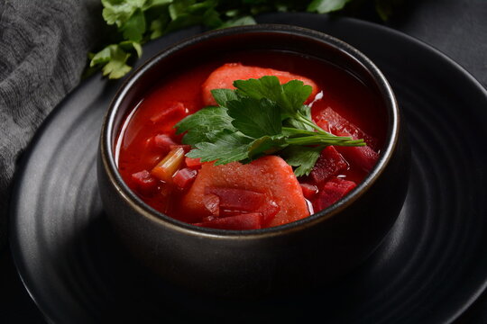 Hot red beet Kubbeh soup, a famous middle eastern dumplings soup dish, served in a bowl. A Jewish-Iraqi traditional matfuniya winter soup. Levantine dish made of bulgur, minced onions, ground  beef