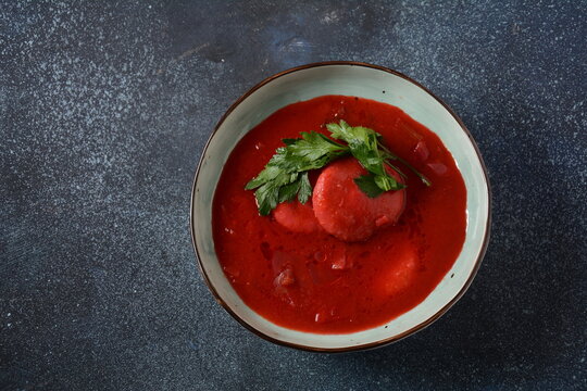Hot red beet Kubbeh soup, a famous middle eastern dumplings soup dish, served in a bowl. A Jewish-Iraqi traditional matfuniya winter soup. Levantine dish made of bulgur, minced onions, ground  beef