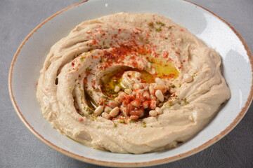 Classic hummus with olive oil on the plate and pita bread.
