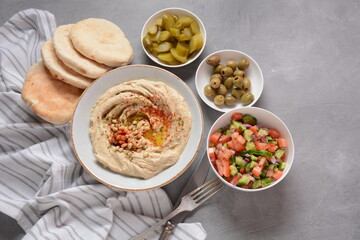 Classic hummus with olive oil on the plate and pita bread.