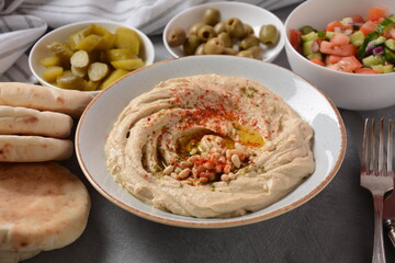 Classic hummus with olive oil on the plate and pita bread.