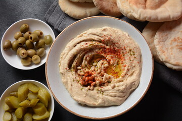 Classic hummus with olive oil on the plate and pita bread.