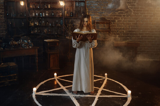 Woman with book of spells standing in magic circle