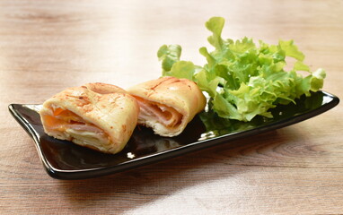 bread stuffed slice ham pork and cheese with vegetable on plate