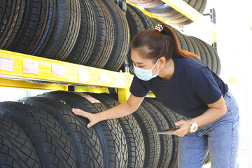 Salesman with showing wheel tires at car repair service or auto store, business, maintenance and people concept