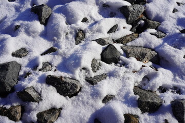 Sonnige schneebedeckte Steine 