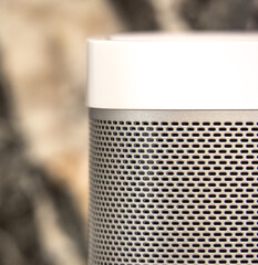 Partial Front view of a modern active loudspeaker with white top cover and a brushed aluminum front...