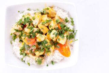 Coconut and mango curry with diced chicken and sliced carrots over coconut rice