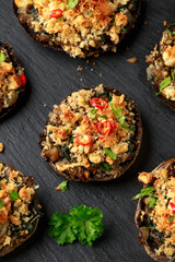 Stuffed mushrooms with spinach, bread crumbs and cheese on stone board