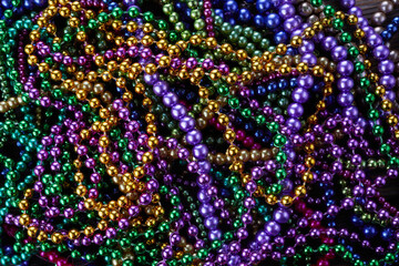 Colorful Mardi gras beads background. Green, purple and gold Merdi gras beads - obrazy, fototapety, plakaty