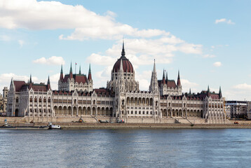 Fototapeta na wymiar The magnificent building of the Hungarian Parliament on the Danube River embankment. Summer sunny day. Budapest, Hungary.