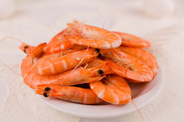 beautiful large boiled tiger prawns on a white plate on the kitchen table