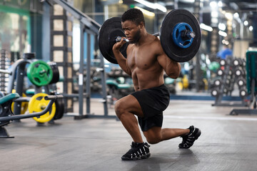 Shirtless black guy sportsman making squats with barbell