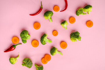 Broccoli, pepper and carrot on pink background