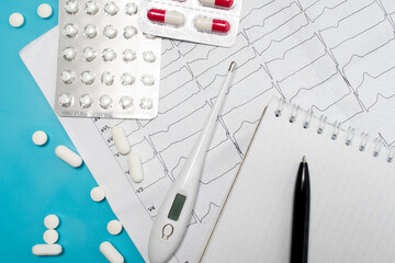 Treatment of heart disease. Myocardial. Stroke. Heart cardiogram, doctor's notebook and pills on a blue background