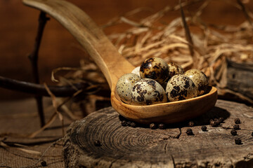 Quail eggs in a wooden bowl and spoon on wooden background