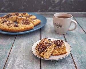 Homemade cookies with chocolate, icing sugar and walnuts and tea in a white mug