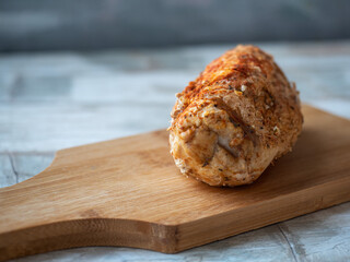 Chicken ham baked with spices on a kitchen board lehazhey on a blue tray