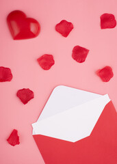 open envelope with blank,  heart and rose petals on pink background 