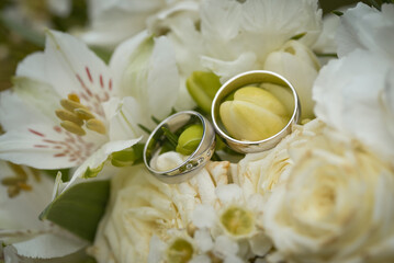 Wedding rings on a bouquet of white flowers