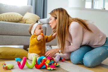 Child girl and her mother playing together with toys and having fun at home