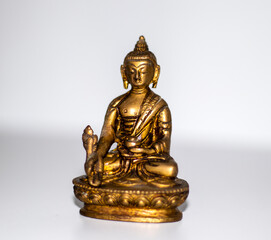 Close up shot of a bronze buddha mini statue. Indoors