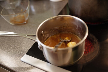 honey and butter are melted in a saucepan on the stove in kitchen 