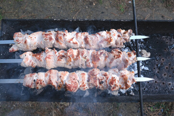 A man is preparing an outdoor barbecue outside his house. Man standing and prepared by the grill outdoors.
