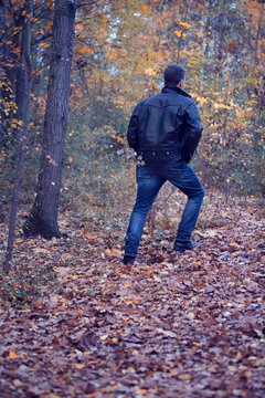 Back Of Man In Black Leather Jacket Walking In The Forest