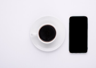 cup of coffee and phone on white background
