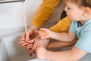 Beautiful young family are washing their hand. Protection against infection and virus.