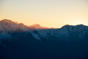 The rays of the setting sun illuminate the peaks of the mountains on the ridge