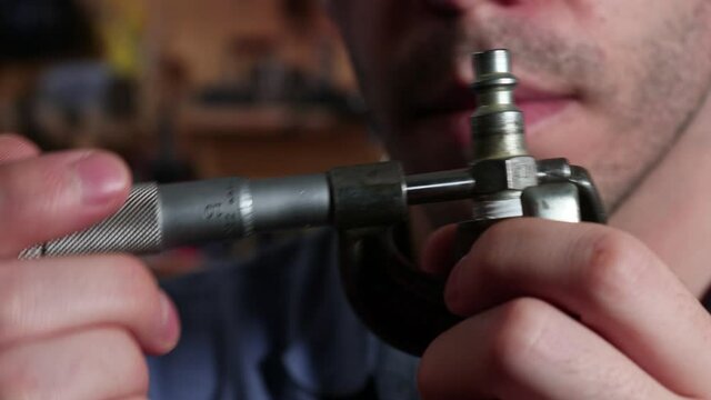 Machinist Uses Micrometer to Precisely Measure Metal Machine Part 