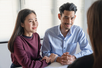 Young family couple talking with property real estate agent about home loan contract purchase agreement